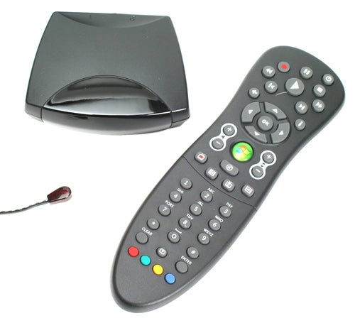 A Gateway remote control with numerous buttons, including a multi-colored section at the bottom, next to a black receiver device and an infrared USB receiver with a cord.