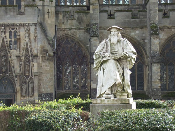 Statue of a historical figure in front of an intricate gothic church facade, captured with Fujifilm FinePix F20, showcasing the camera's color reproduction and detail in natural light conditions.