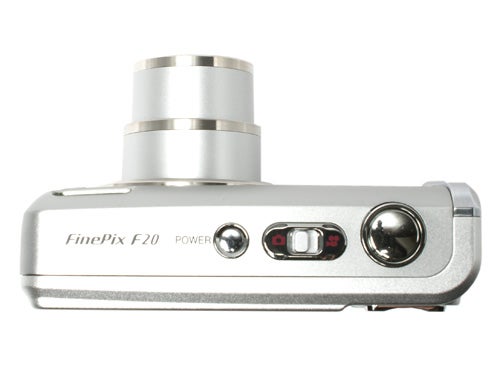 Fujifilm FinePix F20 digital camera viewed from the top, showcasing the silver body, lens, and control buttons.