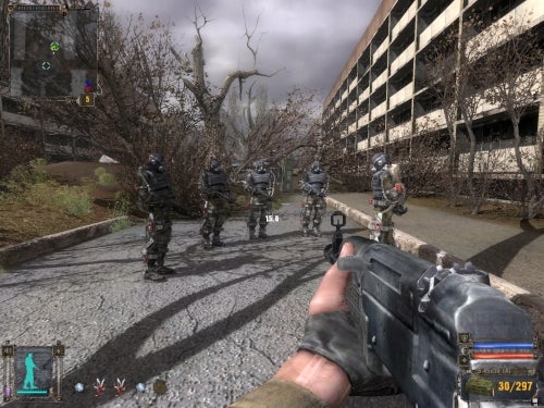 Screenshot from the game S.T.A.L.K.E.R: Shadow of Chernobyl showing a first-person view where the player's character is holding a gun, facing a group of soldiers in a desolate urban environment.