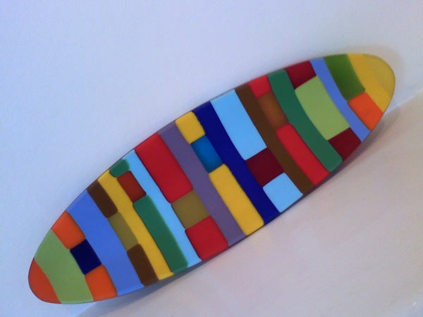 Surfboard-shaped object with multicolored mosaic pattern design.
