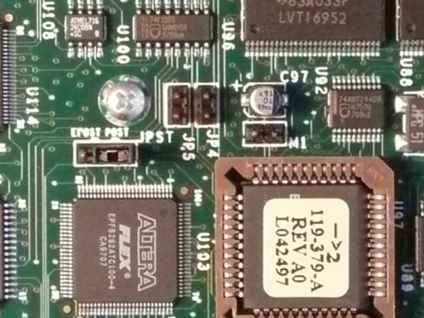 Close-up view of an electronic circuit board with microchips and capacitors, possibly from the internal components of a Panasonic Lumix DMC-TZ2 camera.