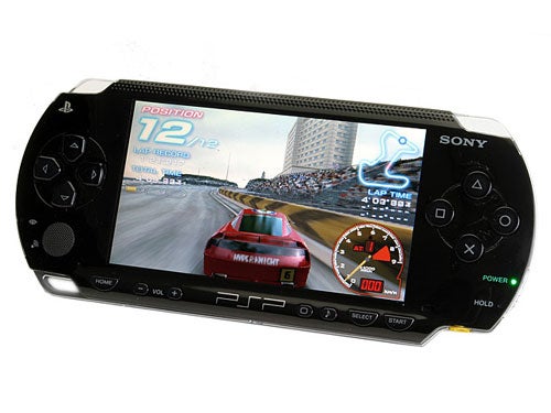 Sony PlayStation Portable (PSP) with a racing game on the screen, showcasing gameplay and handheld device design.