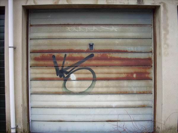 Rusty garage door with graffiti marks on it.