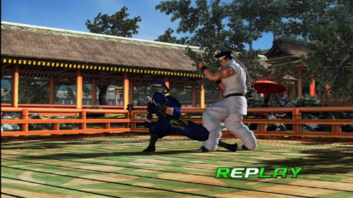 Screenshot from Virtua Fighter 5 showing two characters in a fighting stance mid-battle during a replay sequence with a traditional Japanese pavilion in the background.