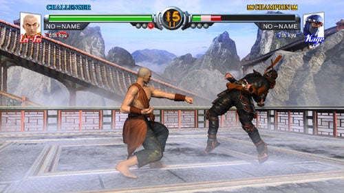 Screenshot of Virtua Fighter 5 video game showing two characters engaged in a fight, with one character executing a kick against the other on a fighting stage with traditional architecture and mountains in the background.