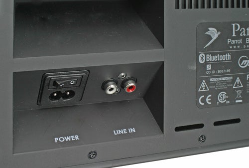 Close-up view of the back panel of a Parrot Boombox showing the power socket and line-in audio inputs. The product label with Bluetooth logo and various certification marks, such as CE and SP, is visible at the top right.