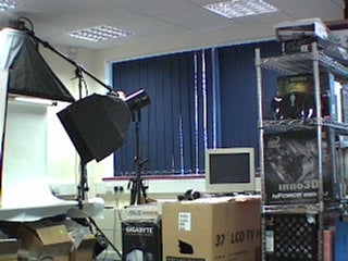 A cluttered office space with computer equipment, boxes, and shelves, possibly captured by a TRENDnet TV-IP201W IP camera.