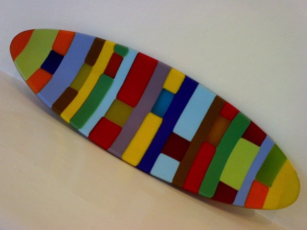 Brightly colored abstract geometric pattern skateboard on a white background.