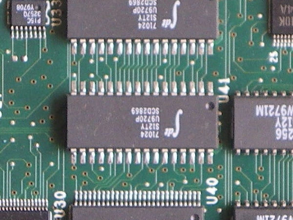 Close-up of an electronic circuit board featuring various integrated circuits and components, potentially illustrating the internal hardware of a digital camera like the Pentax Optio M30.