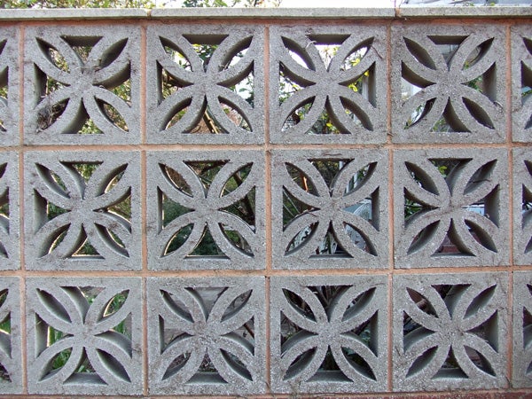 Decorative concrete block wall with symmetrical floral patterns.