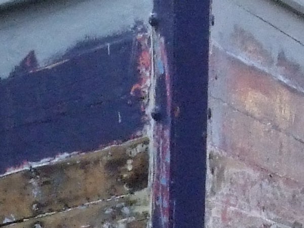 The image provided does not correspond to a product review related to Fujifilm FinePix Z5fd. Instead, it's a low-resolution photo showing a close-up of a weathered edge of a boat with peeling paint and rust.