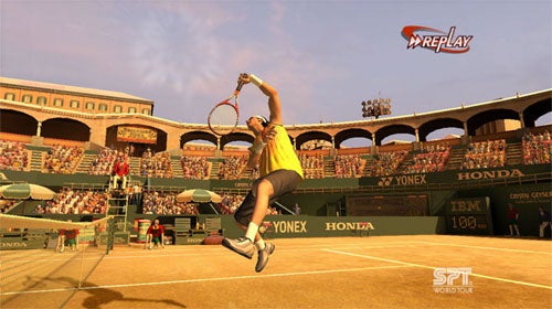 Screenshot of Virtua Tennis 3 video game showing a player character performing a high jump to hit a tennis ball during a match on a clay court with a crowd of spectators in the stands and game sponsorship banners in the background.