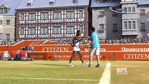 Screenshot from Virtua Tennis 3 video game showing two tennis players shaking hands at the net after a match with a stadium crowd and sponsorship banners in the background.