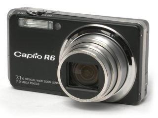 Black Ricoh Caplio R6 digital camera with lens extended, displayed against a white background, highlighting the 7.1x optical zoom and 7.2 megapixel resolution features on the camera body.