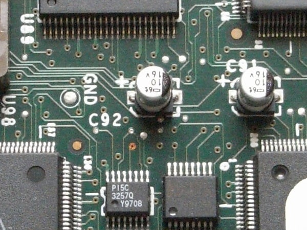 Close-up of an electronic circuit board showcasing integrated circuits, resistors, and capacitors with visible identifiers and connection points.