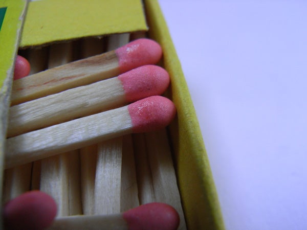 Close-up photo of a box of matches with attention to detail, showcasing the texture and color of the match heads.