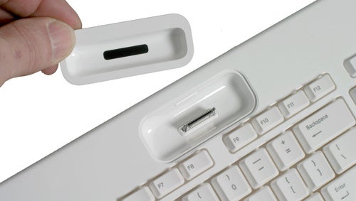 Close-up of a Razer Pro|Type keyboard with a white keycap being removed, revealing an underlying mechanical switch and a USB port within the keyboard housing.