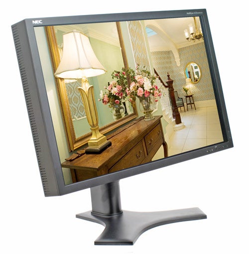 NEC MultiSync LCD2690WUXi monitor displaying a colorful interior room scene with a lamp and flowers on a screen, placed against a white background.