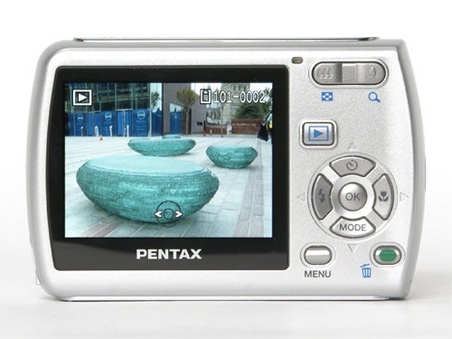 A Pentax Optio E30 digital camera displaying an image on its LCD screen, showcasing its user interface and external controls.