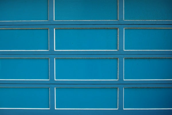 Close-up photo of a pattern of blue rectangular tiles on a wall with distinct white grout lines.