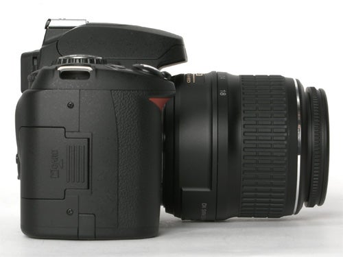 Nikon D40x DSLR camera with a zoom lens attached, photographed from the side against a white background.