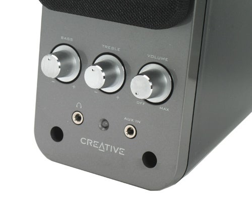 Close-up of the Creative GigaWorks T20 Series II 2.0 Multimedia Speaker System with focus on the front panel showing bass, treble, and volume control knobs, as well as the headphone jack and auxiliary input, with the Creative logo visible below the inputs.