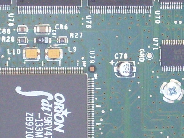 Close-up of a Samsung L700 camera's circuit board showing capacitors, resistors, and an ORION chip.