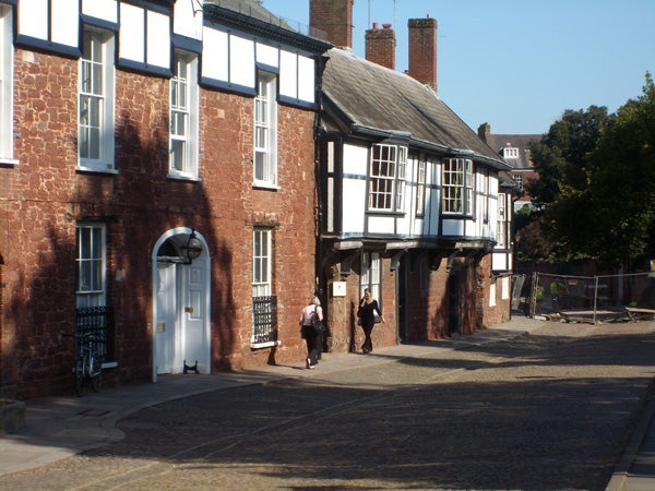 Photograph of a traditional cobblestone street with Tudor-style architecture taken with a Samsung L700 camera.