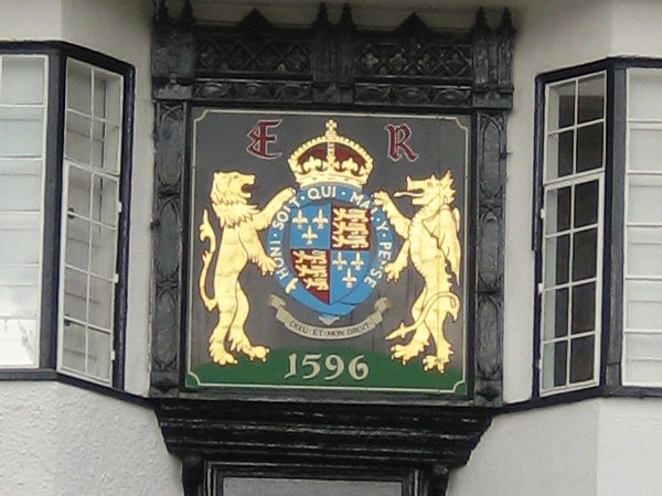 Ornate crest with lions and date 1596 on building facade.