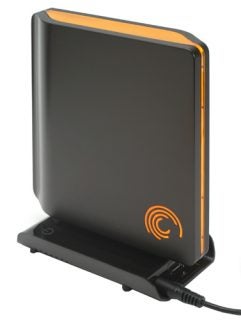 Seagate FreeAgent Pro external hard drive standing on a docking station with an illuminated orange logo on a dark background.