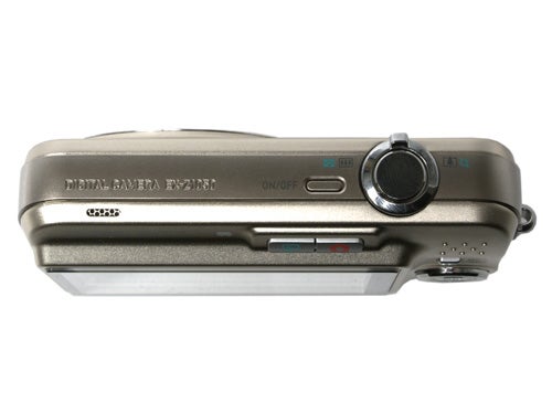 Casio Exilim EX-Z1050 digital camera shown from a side angle, highlighting the lens barrel, power button, and compact size of the metallic beige body.