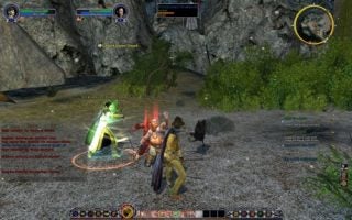 A screenshot from the game Lord of the Rings Online: Shadows of Angmar showing player characters engaging in combat with an enemy creature in a rocky terrain environment, with the game's user interface visible including health bars, a mini-map, and chat text.