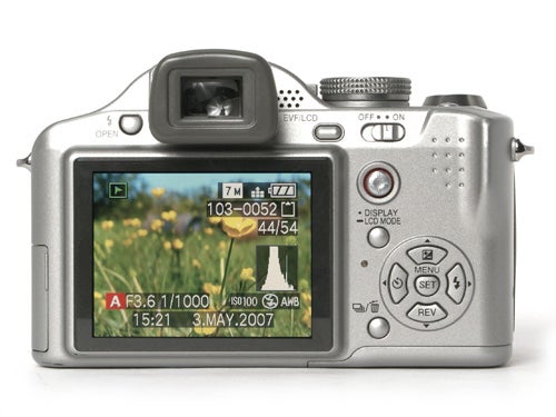 Panasonic Lumix DMC-FZ8 digital camera displayed on a white background, showing the LCD screen with a photo preview, camera settings, and date visible.