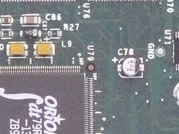 Close-up of an electronic circuit board showing various components such as capacitors and microchips.