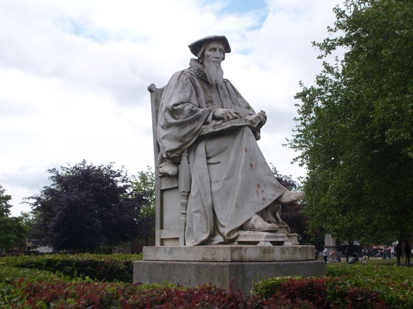 Statue in a park with trees and bushes in background
