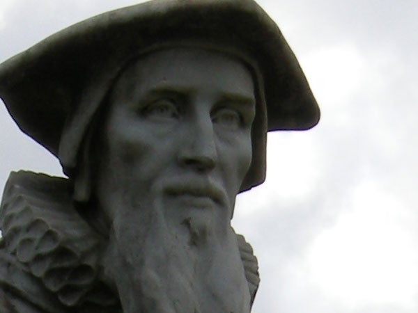 Close-up of a statue's face against a cloudy sky.