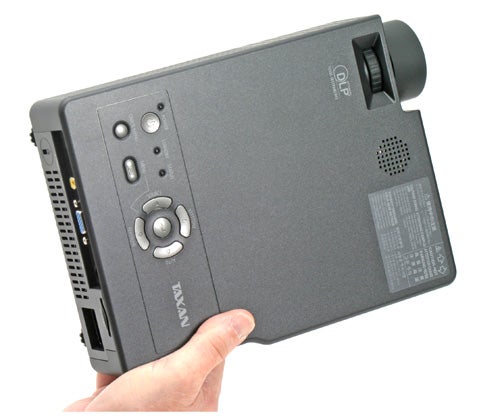 Hand holding Taxan KG-PS125X wireless DLP projector.
