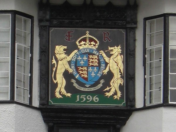 Coat of arms on building facade with lions and crown, dated 1596.