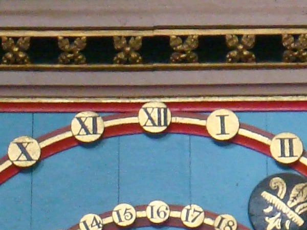 Close-up of ornate clock face with Roman numerals.
