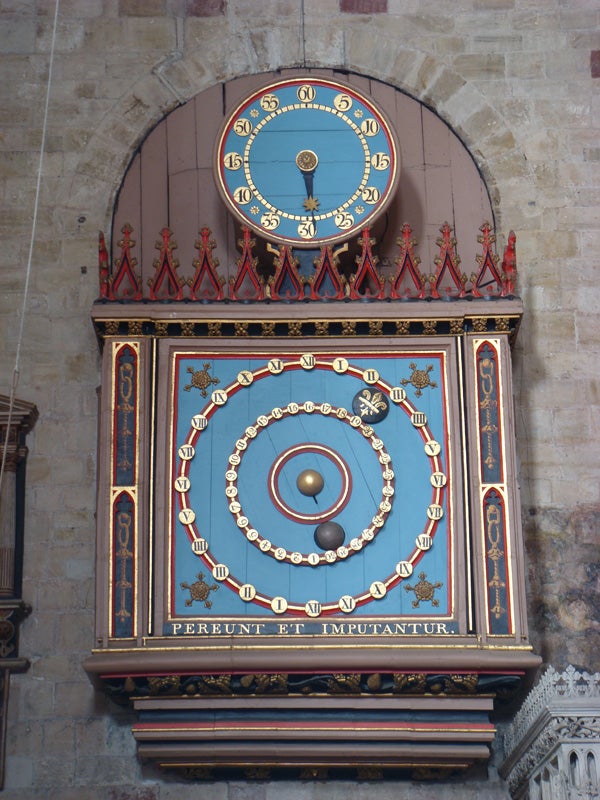 Ornate astronomical clock on a cathedral wall