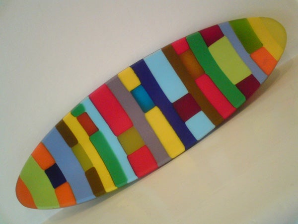Colorful surfboard-shaped object with geometric patterns