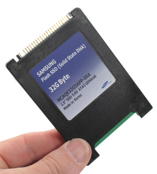 Hand holding a Samsung 32GB Solid State Drive.