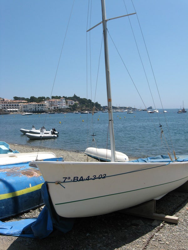 Seaside photograph with boats and clear blue sky.