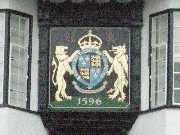 Emblem with lions and crest on a building facade.