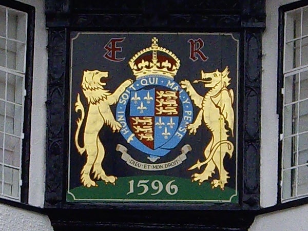 Coat of arms on a building with lions and a crown.