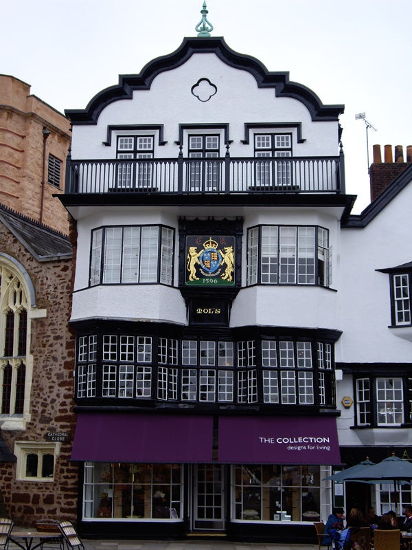 Photo of a historic half-timbered building with a crest.