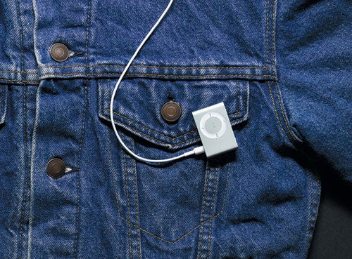 Apple iPod Shuffle 1GB clipped to blue denim jacket.