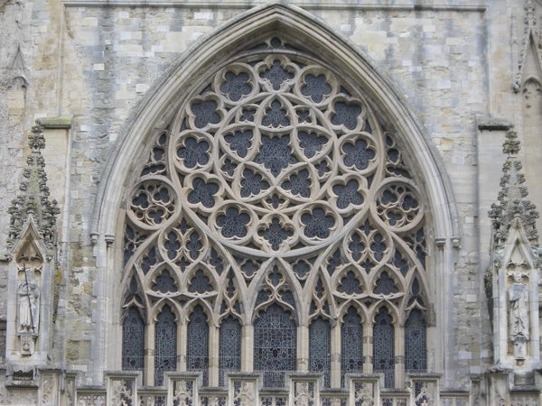 Intricate gothic window architecture on cathedral facade.
