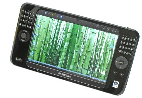 Samsung Q1 Ultra mobile PC with forest wallpaper on screen.